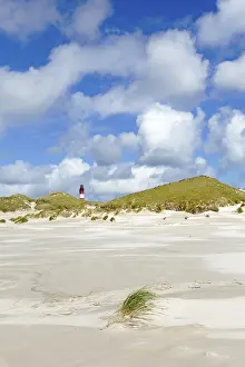 Deserted Coastline Germany Drucke: Dunes with lighthouse and cloudy sky