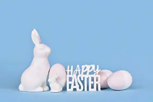 Pastel Colored Background Drucke: Easter eggs, bunny and text Happy Easter on blue background with copy space