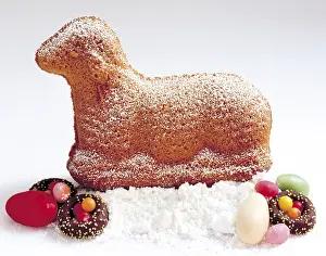 Cute Easter Treats Drucke: Easter lamb made of sponge cake sitting on icing sugar with Easter sweets