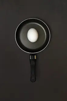 Studio Shot Of Egg Drucke: Egg in pan, dark background