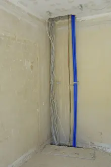 Deserted Construction Area Drucke: Electric cables and empty conduits on a wall