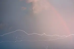 Stormy Atmosphere Drucke: Electric lightning and rainbow in a storm cloud