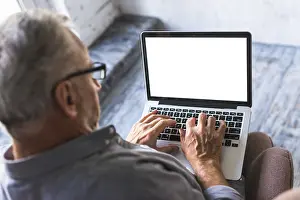 Business Attire Man Working Drucke: Elevated view man using laptop with white blank screen