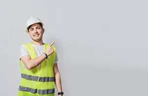 Construction Worker Portrait Drucke: Engineer man pointing to side. Builder engineer pointing finger to the right isolated