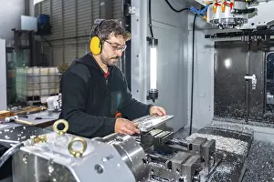 CNC Milling Machine Operator Drucke: Engineer working with a milling cnc machine using safety gear