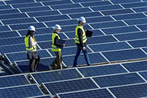 Solar Panel Inspection Drucke: Engineers in hard hats and vests walking on a large solar panel array