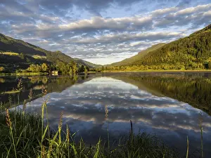 Cloudy Lake Reflection Drucke: Evening light, forest landscape and clouds reflected in the lake