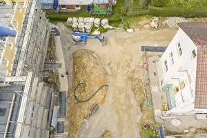 German Federal Republic Construction Sites Drucke: Excavator and construction work on a plot of land next to a white building