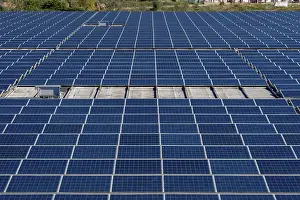 Green Energy Solution Drucke: Extensive array of blue solar panels covering a rooftop