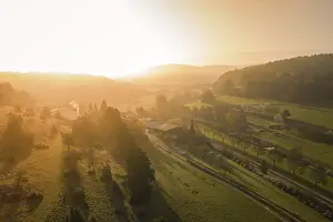 Atmospheric Sunset In Europe Drucke: Extensive panorama of fields and forests in the soft light of sunset