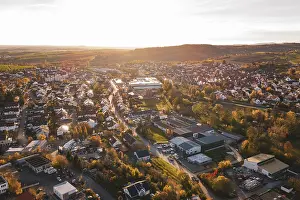 Baden Wurttemberg Evening Light Drucke: Extensive settlement surrounded by fields and trees in autumn at sunset