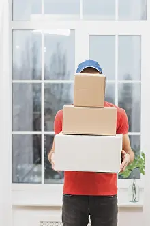 Parcel Delivery Drucke: Faceless courier with stack parcels