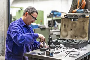 Metal Industrial Factory Drucke: Factory worker operator in the numerical control sector checking the equipment