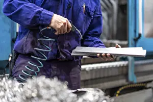 Metal Industrial Factory Drucke: Factory worker operator in the numerical control sector cleaning a part with compressed air