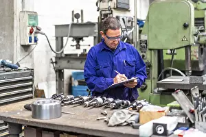 Factory Worker Drucke: Factory worker operator in the numerical control sector making a report