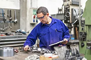 Numerical Control Sector Drucke: Factory worker operator in the numerical control sector making a report