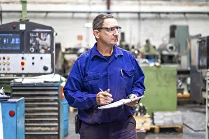 Numerical Control Sector Drucke: Factory worker operator in the numerical control sector making a report to send to suppliers