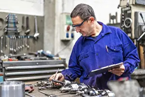 Numerical Control Sector Drucke: Factory worker operator of the numerical control sector measuring the drill bits