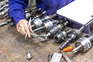 Industrial Factory Work Drucke: Factory worker operator of the numerical control sector measuring the drill bits