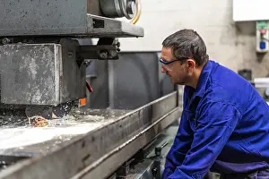 Latin American Laborer Drucke: Factory worker operator in the numerical control sector preparing a machine