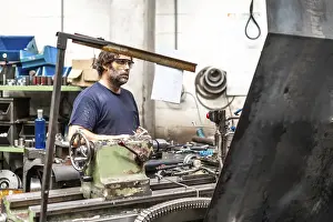 Industrial Factory Work Drucke: Factory worker operator in the numerical control sector working on a machine