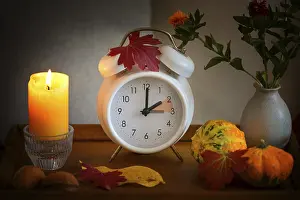 Daylight Saving Time Drucke: Fall back, time change on a white alarm clock after daylight saving time
