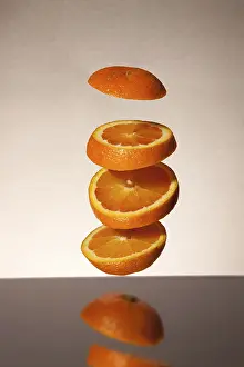 Studio Shot Of Sliced Oranges Drucke: Falling orange slices