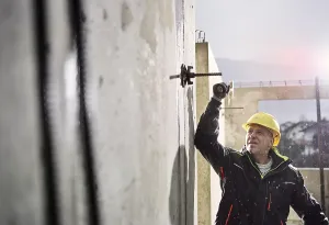 House Building Process Drucke: Construction worker at building site