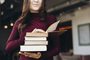 Female Student Learning Drucke: A female student holding a stack of books