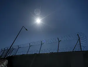 Cloudless Blue Sky Photo Drucke: Fence with barbed wire in front of blue sky
