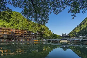 Chinesisch Drucke: Feng Huang, China - August 2019 : Alter Bogenbrücke und traditionelle alte Holzhäuser spiegeln sich im Tuo-Fluss