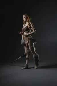 Female Warrior Pose Drucke: A fierce warrior model poses with a bow and arrows