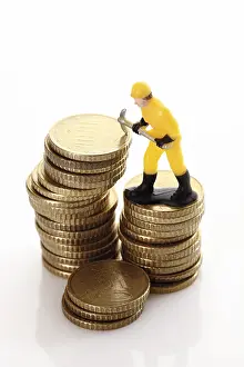 Construction Industry Jobs Drucke: Figure of a construction worker with hard hat and pickaxe on a stack of coins
