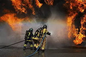 Firefighter In Action Drucke: Fireman working against flames