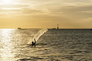 Coastal Scenery Photo Drucke: A fisherman casts a net into the ocean