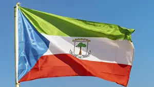 Drucke von Die Flagge von Äquatorialguinea flattert im Wind, isoliert gegen einen blauen Himmel Äquatorialguinea Drucke: Die Flagge von Äquatorialguinea flattert im Wind.