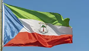 Drucke von Die Flagge von Äquatorialguinea flattert im Wind, isoliert gegen einen blauen Himmel Äquatorialguinea Drucke: Die Flagge von Äquatorialguinea flattert im Wind.
