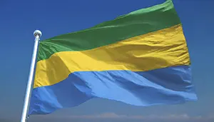 Drucke von Die Flagge Gabuns flattert im Wind, isoliert gegen einen blauen Himmel Gabun Drucke: Die Flagge Gabuns flattert im Wind.