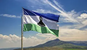 Blue Sky With Flags Drucke: The flag of Lesotho, fluttering in the wind