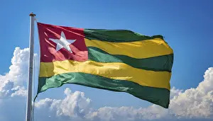 Drucke von Die Flagge von Togo flattert im Wind, isoliert gegen einen blauen Himmel Togo Drucke: Die Flagge von Togo flattert im Wind.