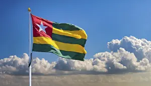 Drucke von Die Flagge von Togo flattert im Wind, isoliert gegen einen blauen Himmel Togo Drucke: Die Flagge Togos flattert im Wind.