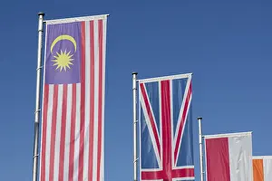 Country Flags Drucke: Several flags of different countries fly side by side under a clear blue sky