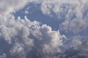 Cloudy Weather Forecast Drucke: Fluffy white clouds float across a serene blue sky