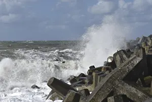 Uninhabited Coastal Landscapes Drucke: Foaming waves hit rough concrete structures on the coast