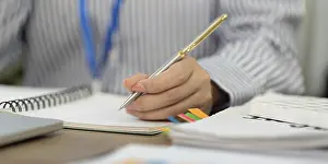 Office Communication Skills Drucke: A focused professional writes notes in a notebook
