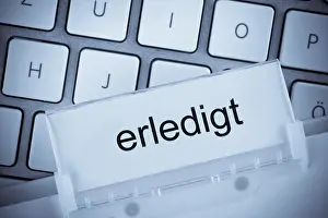 Construction Industry Drucke: The folder of a hanging file in front of a computer keyboard on the topic done