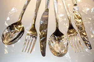 Uninhabited Dining Table Scene Drucke: Fork, spoon and knife with reflections and light effects