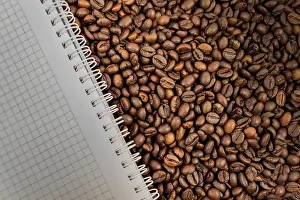 Deserted Desk Scene Drucke: Full frame of coffee beans also with empty notebook