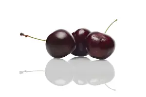 Healthy Eating Nutrition Drucke: Three fresh cherries with reflection on glossy surface