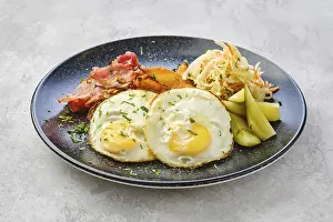 Healthy Breakfast Meal Drucke: Two fried eggs with bacon and pickled cabbage with cucumber